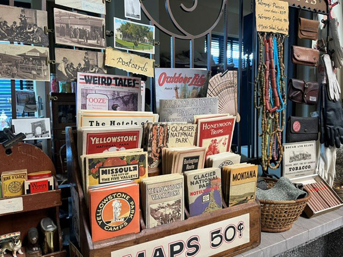 Antique props, including old national park maps, are placed along the old ticket booths inside the train depot in Butte during filming 