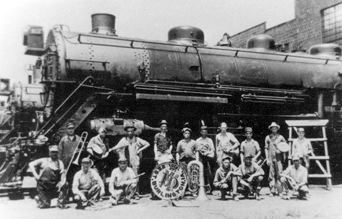 Taken after a weekly rehearsal, the West Burlington Shop Band poses beside a steam locomotive in the late 1920s. Taken after a weekly rehearsal, the West Burlington Shop Band poses beside a steam locomotive in the late 1920s.