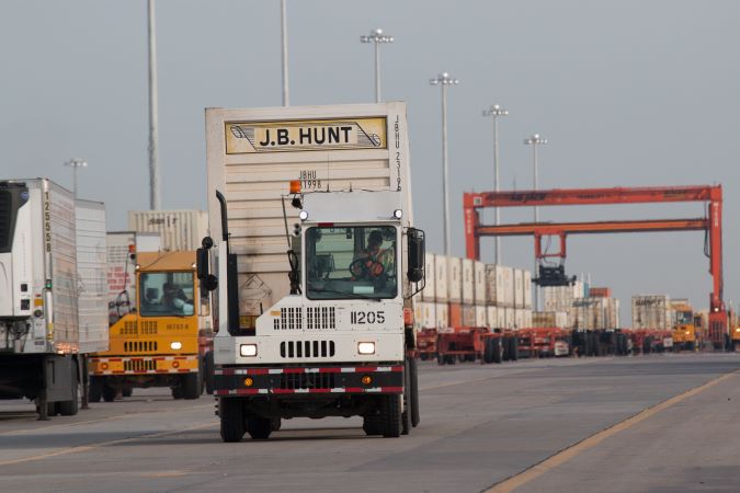 A hostler vehicle moves a freight container within the facility. A hostler vehicle moves a freight container within the facility.
