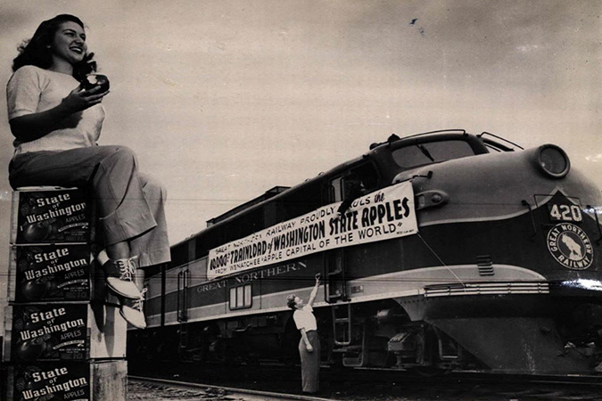 Appleland Princess Lois Banghart helps celebrate GN’s 10,000th trainload of apples out of the Wenatchee area in 1947. Appleland Princess Lois Banghart helps celebrate GN’s 10,000th trainload of apples out of the Wenatchee area in 1947.