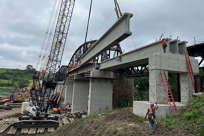 Crews erect the precast girders for span 11. Crews erect the precast girders for span 11.