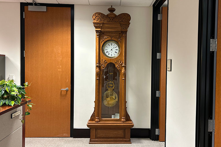 An oak floor clock with a carved crown top An oak floor clock with a carved crown top