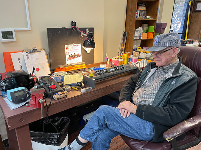 Harold Bryan sitting next to a desk inside White’s Chapel Methodist Church, with supplies to fix and maintain the trains Harold Bryan sitting next to a desk inside White’s Chapel Methodist Church, with supplies to fix and maintain the trains
