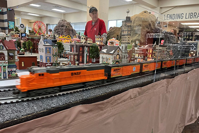 Model BNSF train zooming past the miniature Christmas town Model BNSF train zooming past the miniature Christmas town