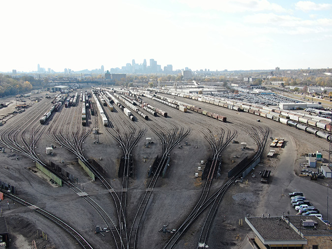 View of the Northtown hump yard, or “bowl,” with secondary retarders in foreground. Master retarder is below bottom edge of photo. Downtown Minneapolis is visible in background. View of the Northtown hump yard, or “bowl,” with secondary retarders in foreground. Master retarder is below bottom edge of photo. Downtown Minneapolis is visible in background.