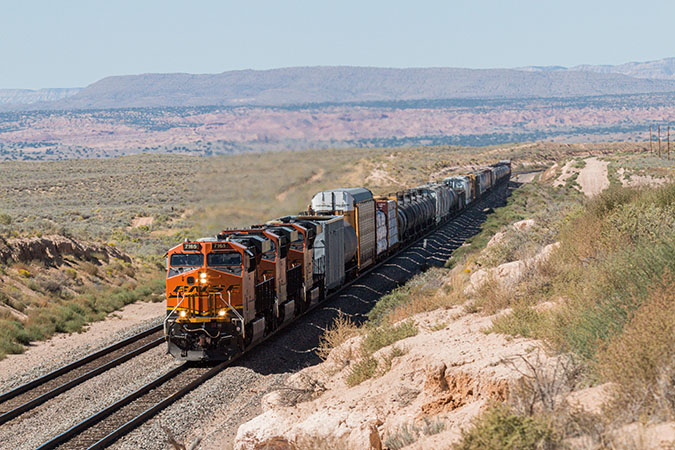 Mixed freight train rolls through desert. Mixed freight train rolls through desert.