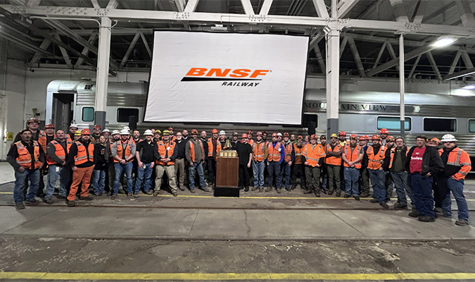Team members at our Topeka System Maintenance Terminal gather around their bell. 