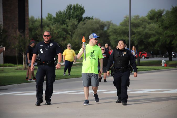 Special Olympics participant holding the Olympic torch. Special Olympics participant holding the Olympic torch.
