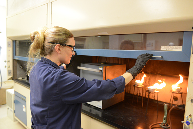 Senior Engineer I Rachel Flott analyzes diesel fuel to determine the ash content. The fuel is ignited to allow it to burn until only ash and carbon remain. Senior Engineer I Rachel Flott analyzes diesel fuel to determine the ash content. The fuel is ignited to allow it to burn until only ash and carbon remain.